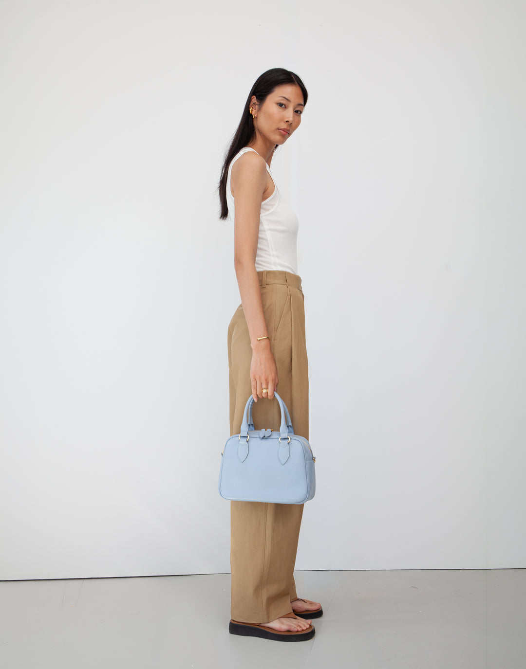 hyer goods la corsa pale blue leather bowling bag held by model's side #color_pale-blue