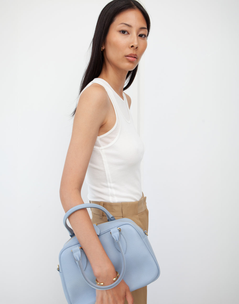 hyer goods la corsa pale blue leather bowling bag on model's forearm #color_pale-blue