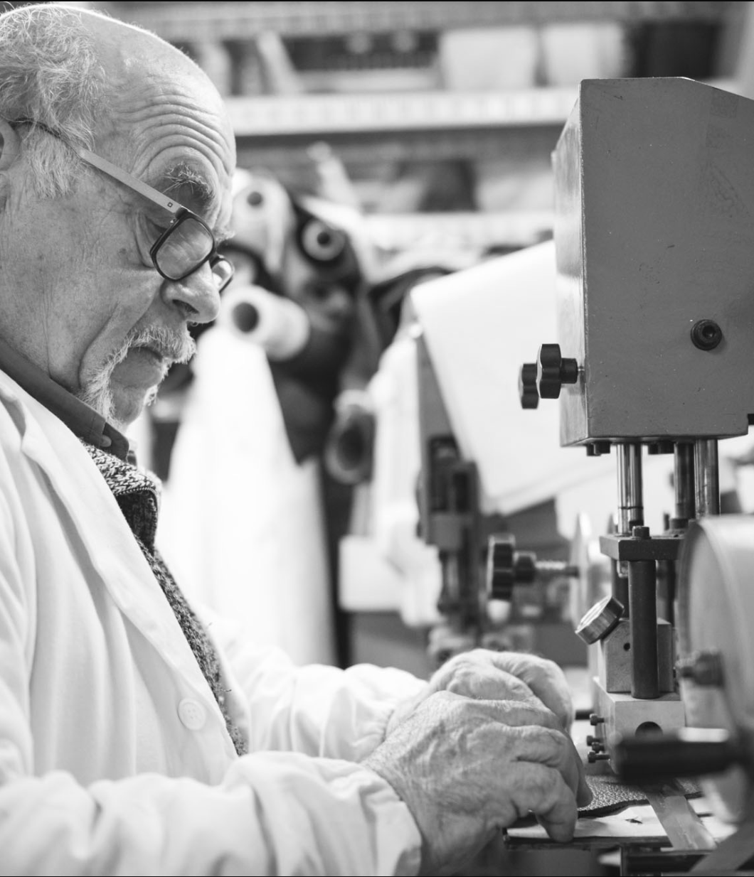 Artisan crafting Italian leather handbags in a small-batch factory
