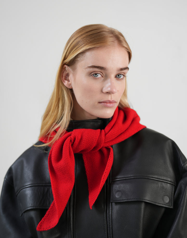 a woman wears a black leather jacket and a red bandana scarf tied around her neck  #color_red