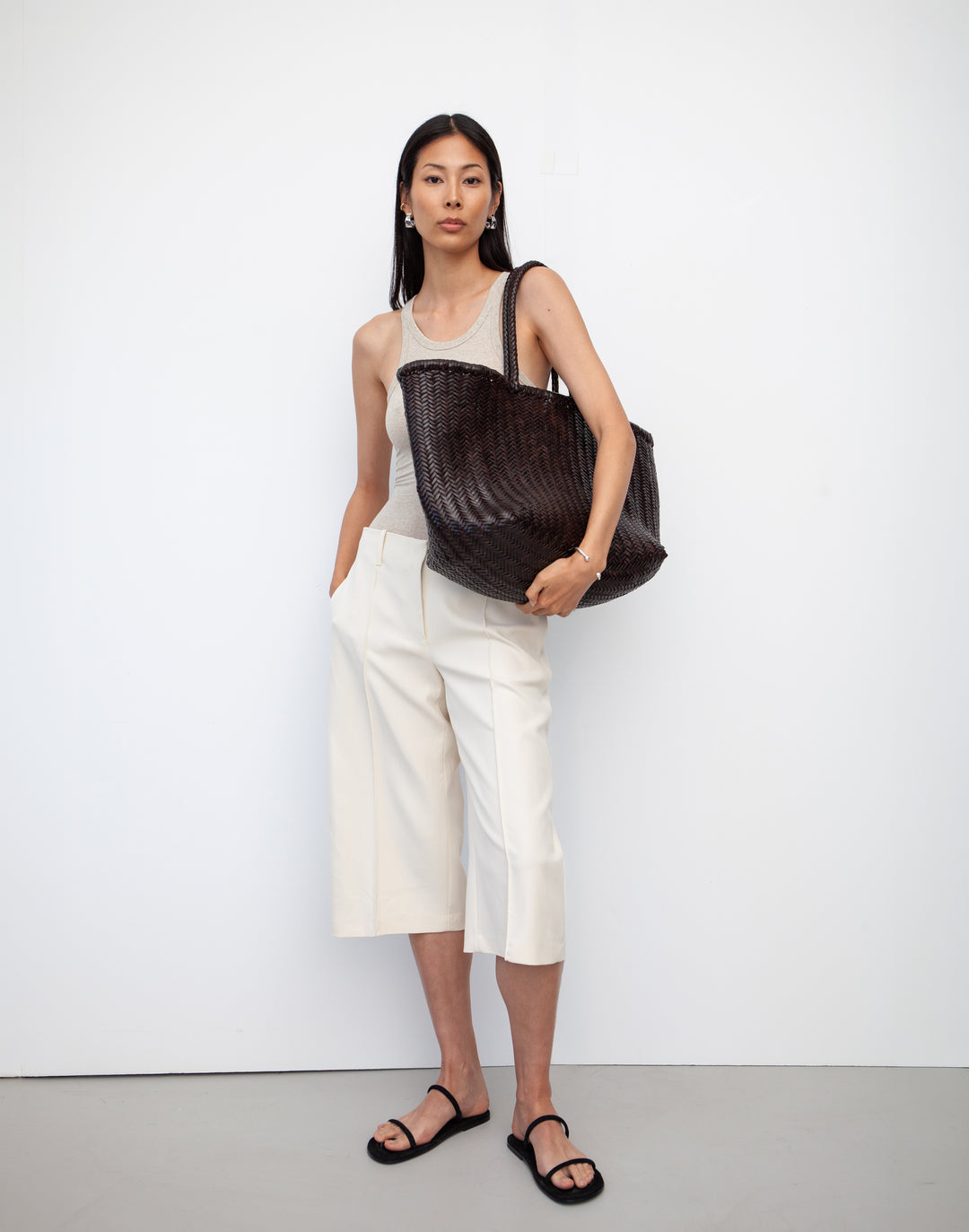 hyer goods tan woven leather oversized mercato summer tote bag on model's shoulder #color_dark-chocolate